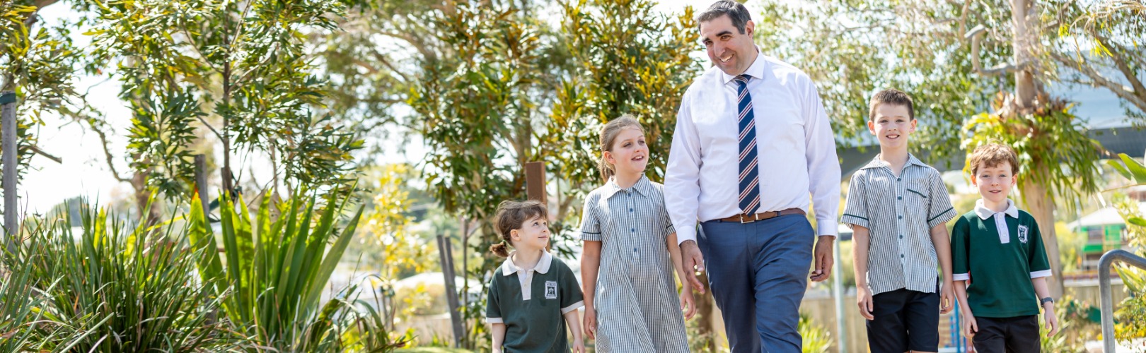 chool principal walking with students around the campus, speaking and engaging with them.